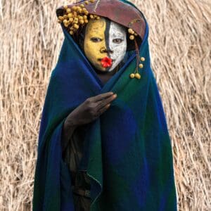 Suri Woman With Face Paint and adorned with a gourd and shroud.